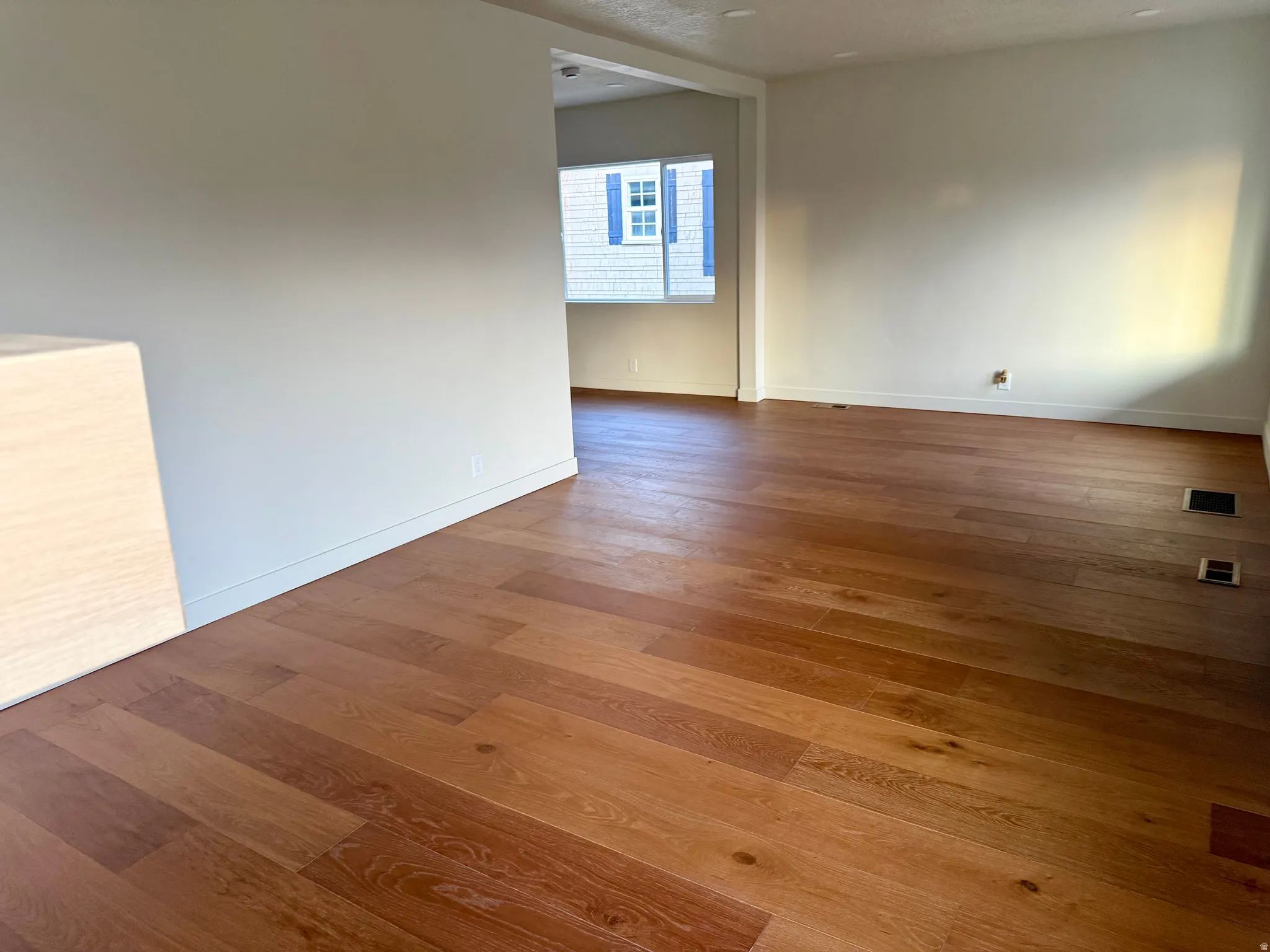 Unfurnished room with wood finished floors and baseboards