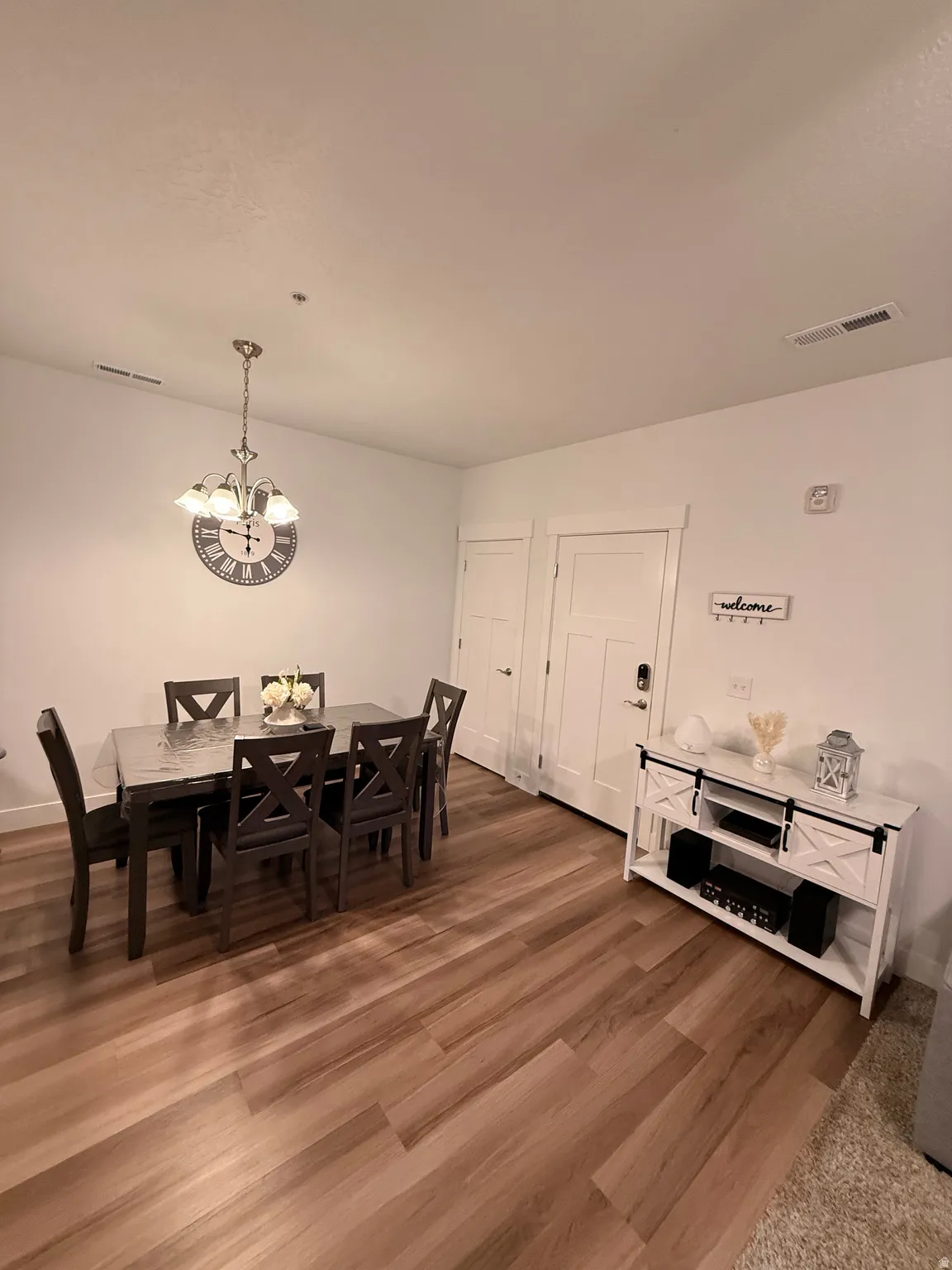 Dining space featuring light wood-type flooring and a chandelier