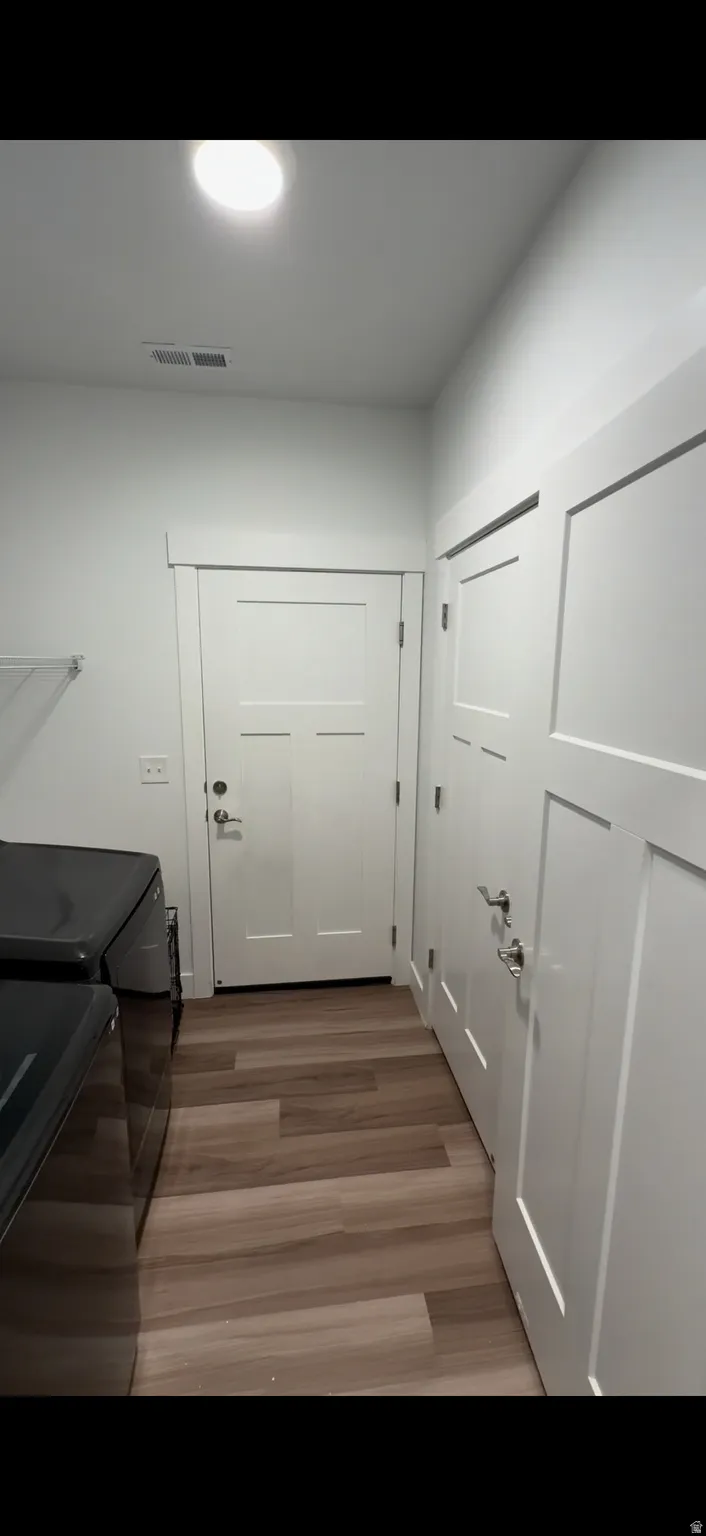 Laundry area with light wood-style flooring and washer and dryer