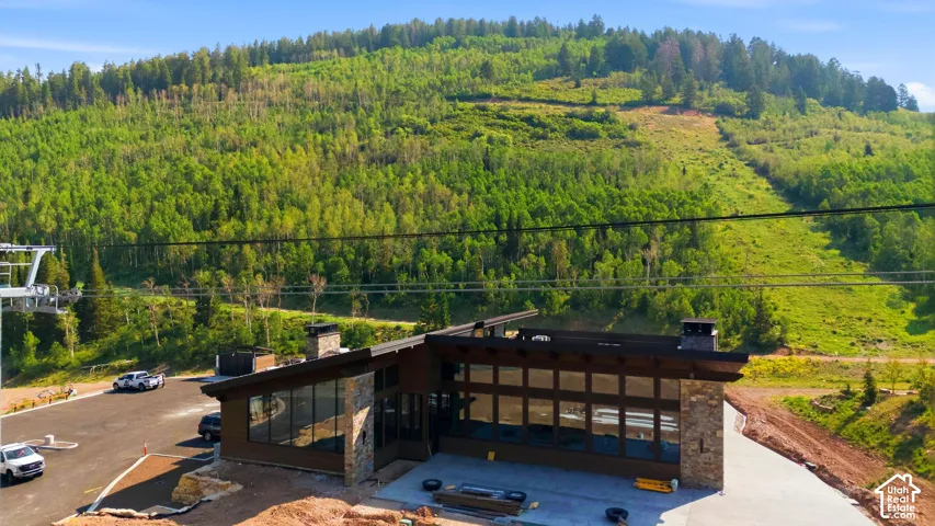 Contemporary architectural design featuring extensive window walls, stone accents, and a dark-toned roofline