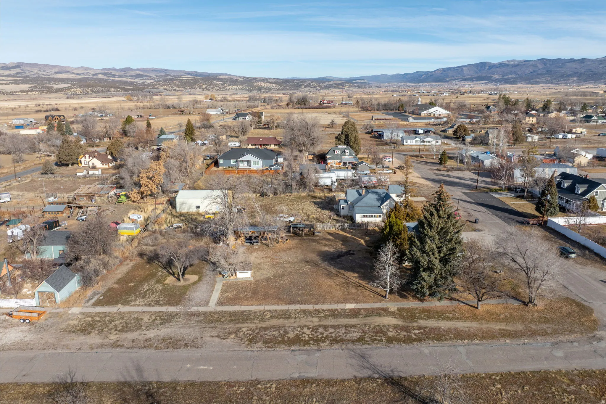 Aerial view of property and surrounding area with a mountain backdrop and nearby suburban area
