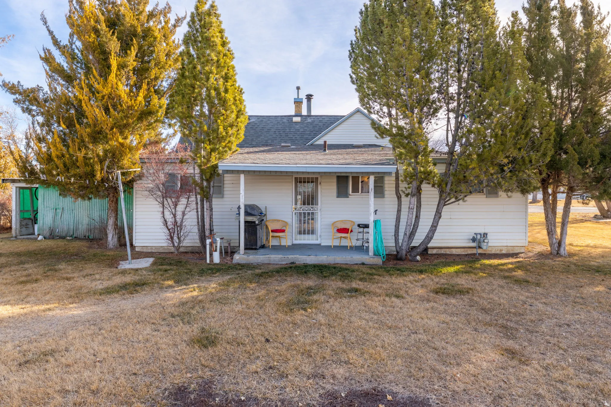 Rear view of property featuring a yard and roof with shingles
