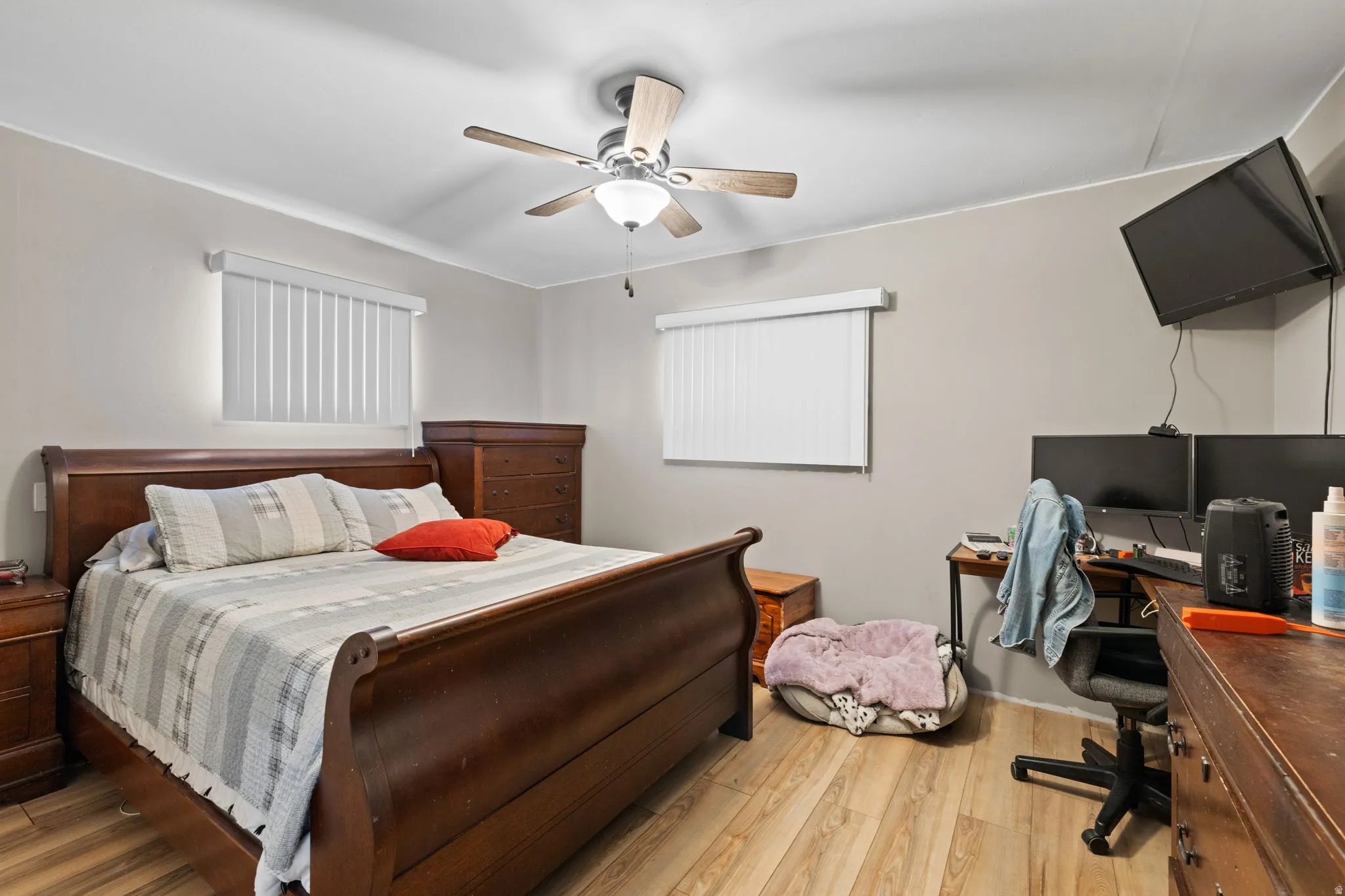 Bedroom featuring wood finished floors, a ceiling fan, and an office area