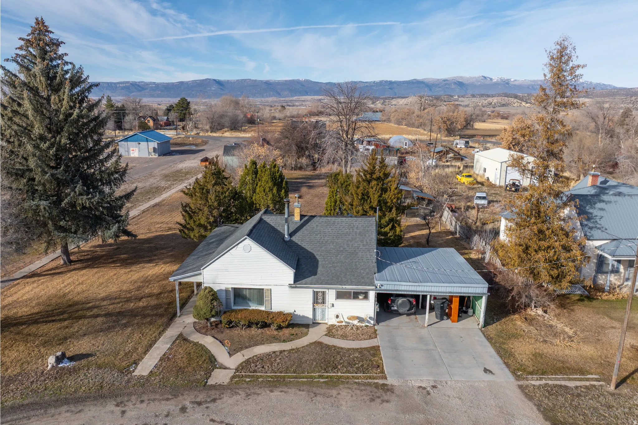 Aerial view of property and surrounding area featuring a mountainous background