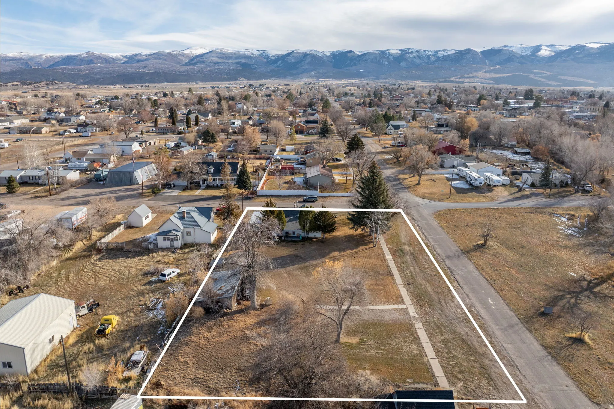 Aerial view of residential area with mountains and property parcel outlined
