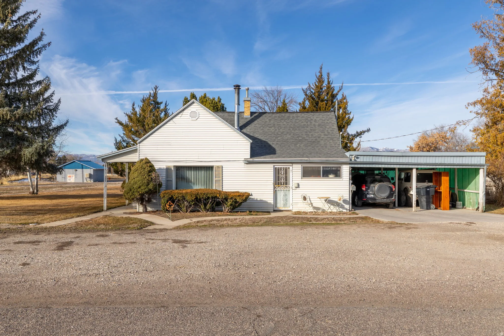 View of front of property with a carport, driveway, and roof with shingles