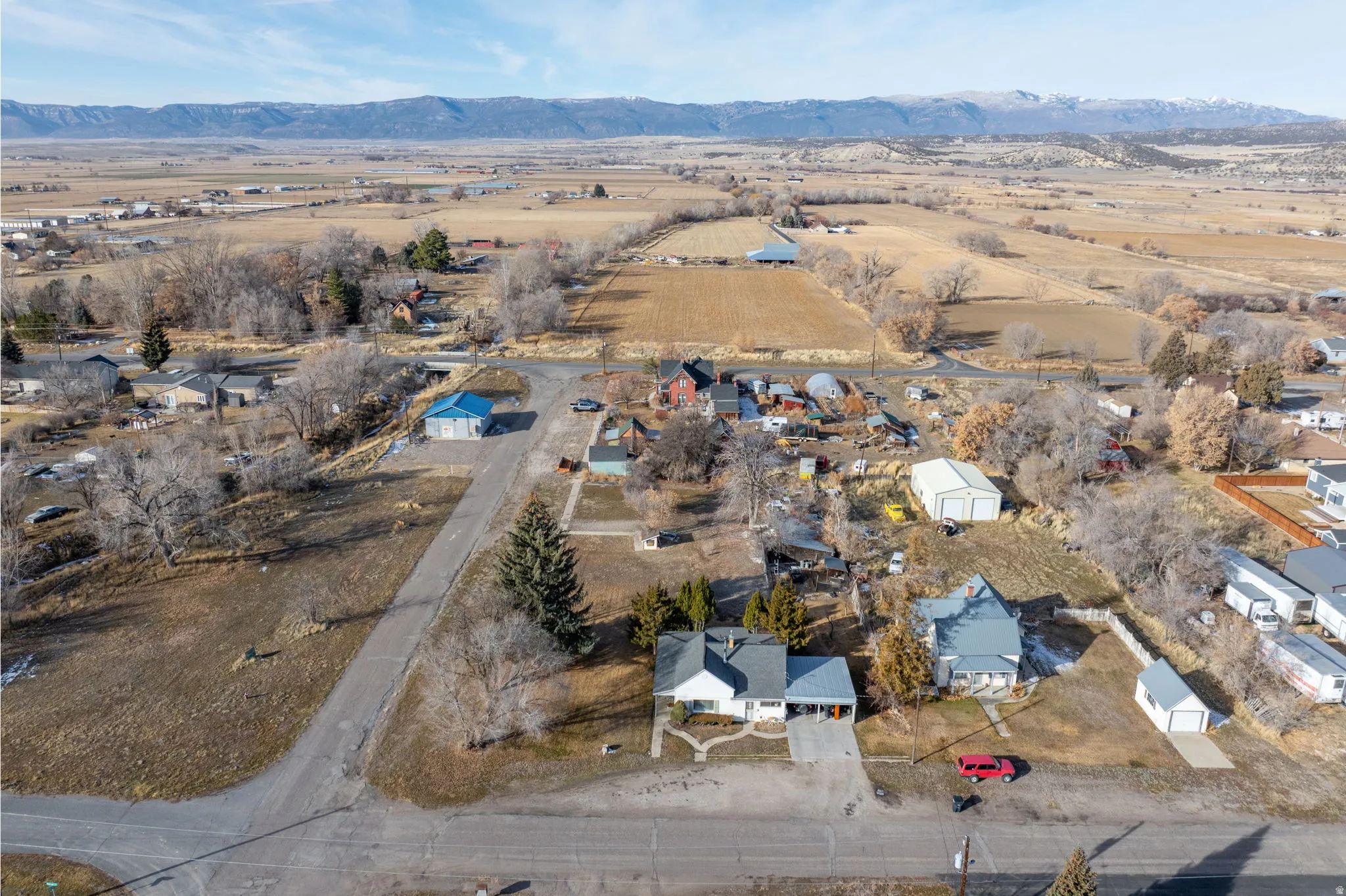 Aerial view of property's location with rural landscape, nearby suburban area, and a mountain backdrop