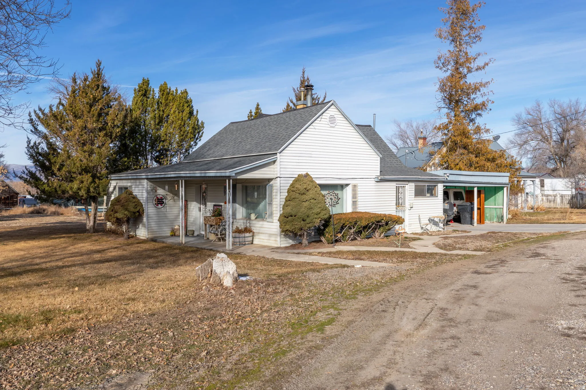 Bungalow with covered porch, an attached carport, a front yard, and driveway