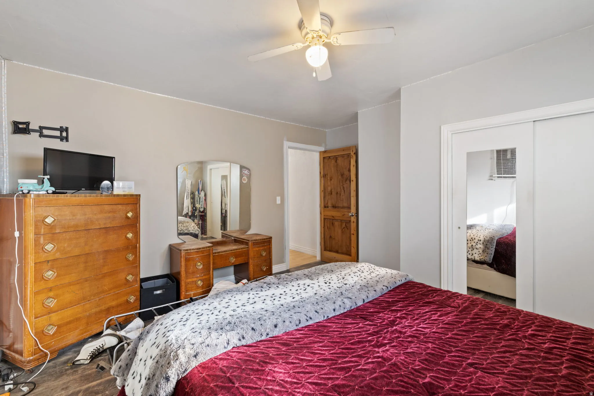 Bedroom featuring a ceiling fan, a closet, and wood finished floors