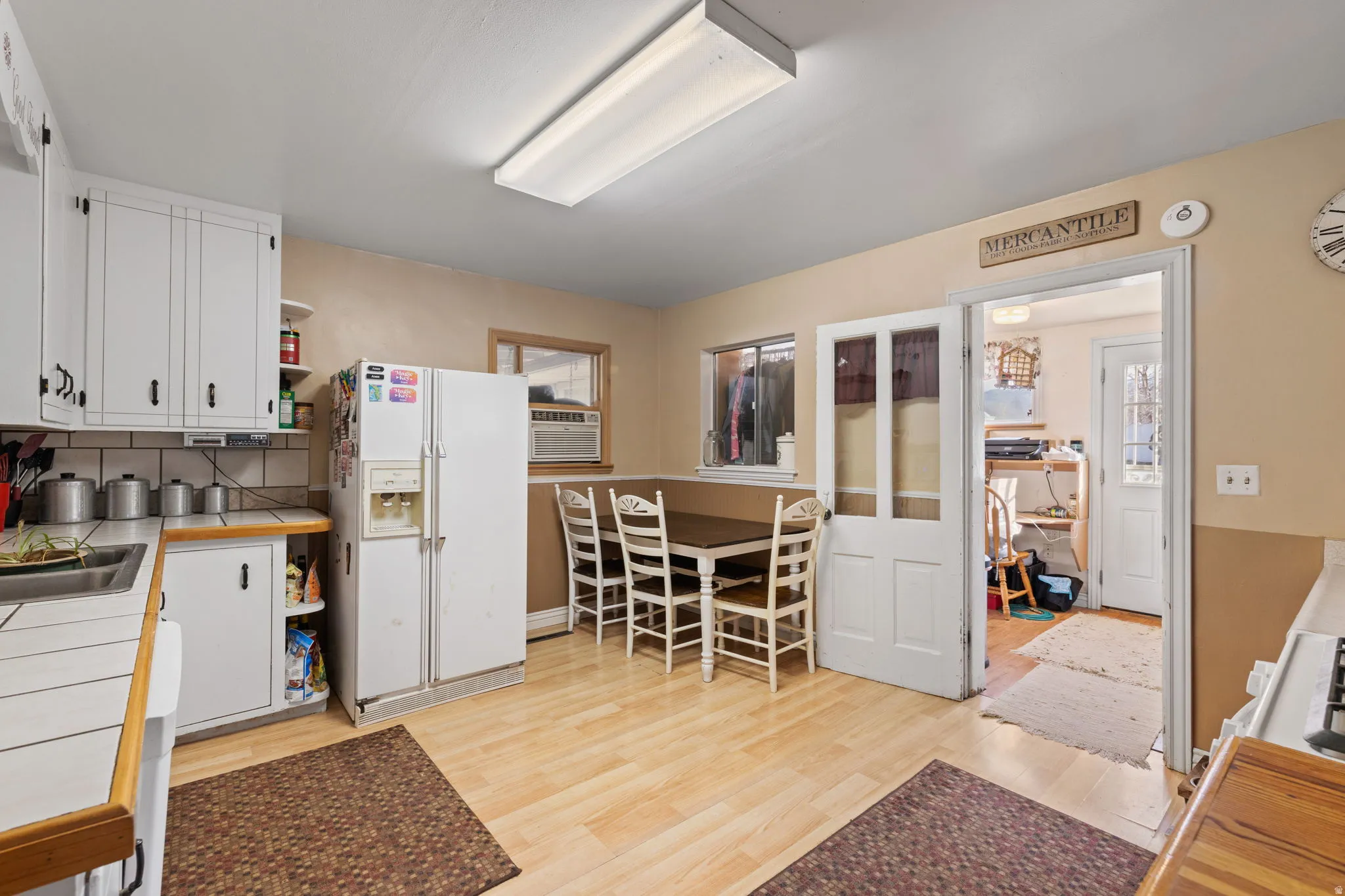 Kitchen featuring open shelves, white cabinetry, white appliances, light wood finished floors, and decorative backsplash