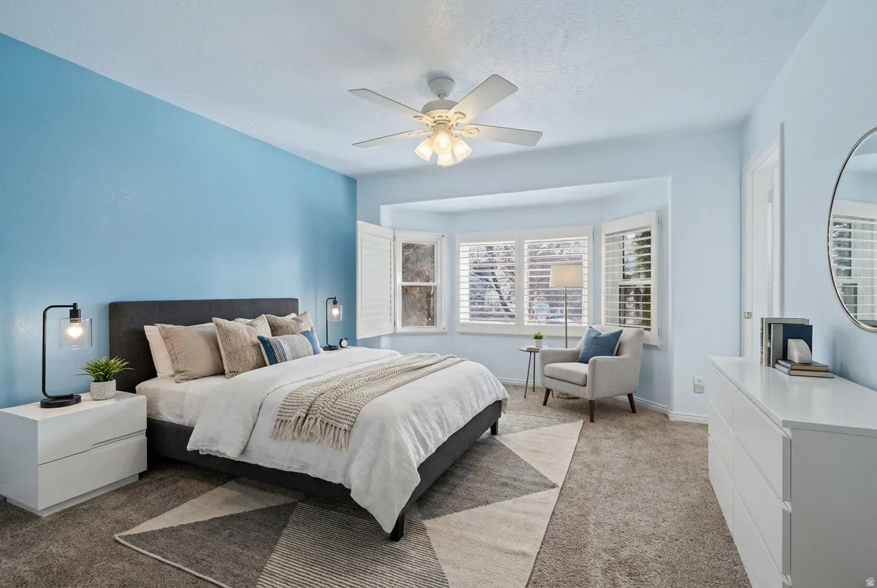 Bedroom with light carpet, ceiling fan, and a textured ceiling