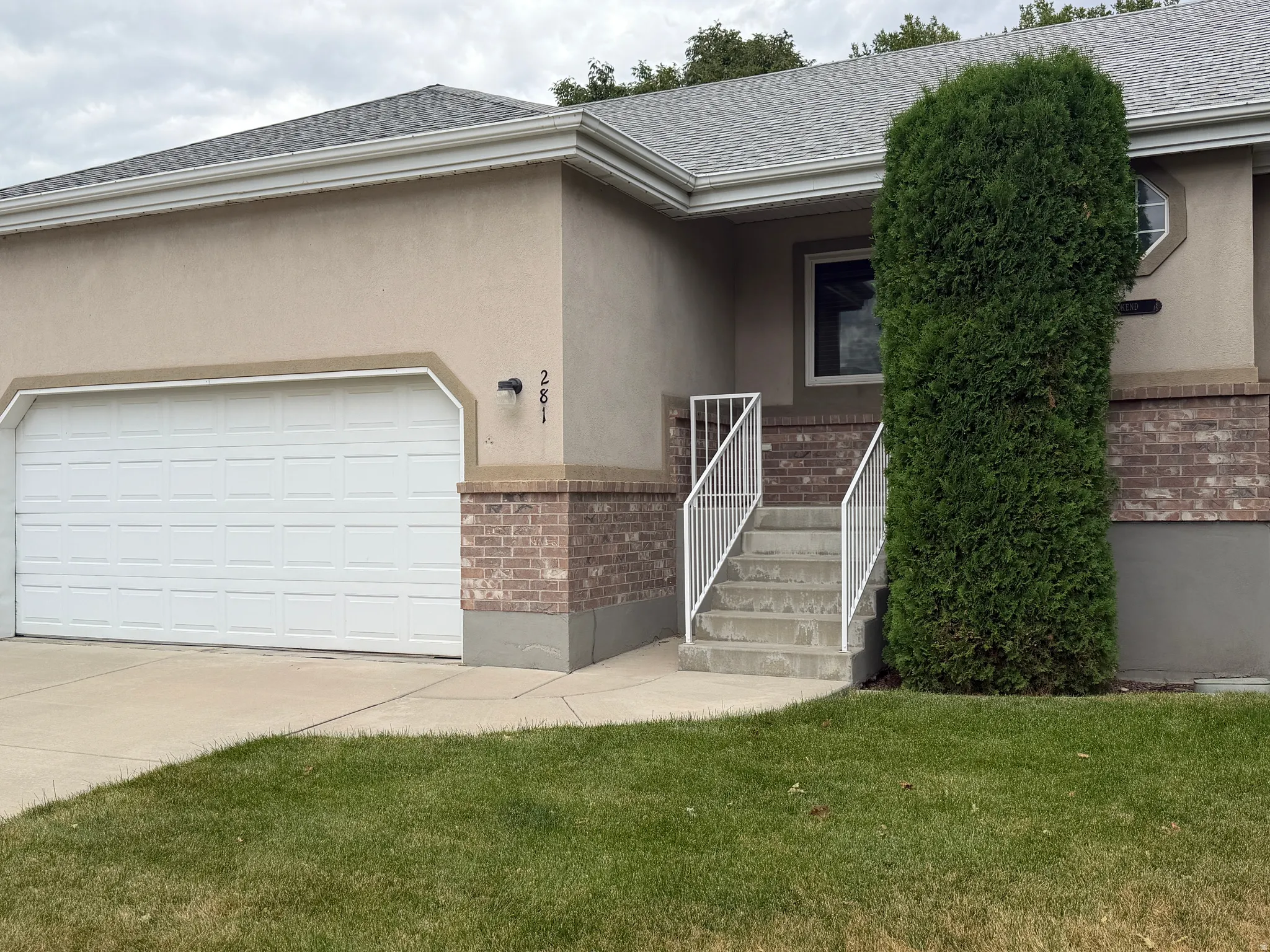 View of the front door and garage. The garage is oversized for large cars or storage.