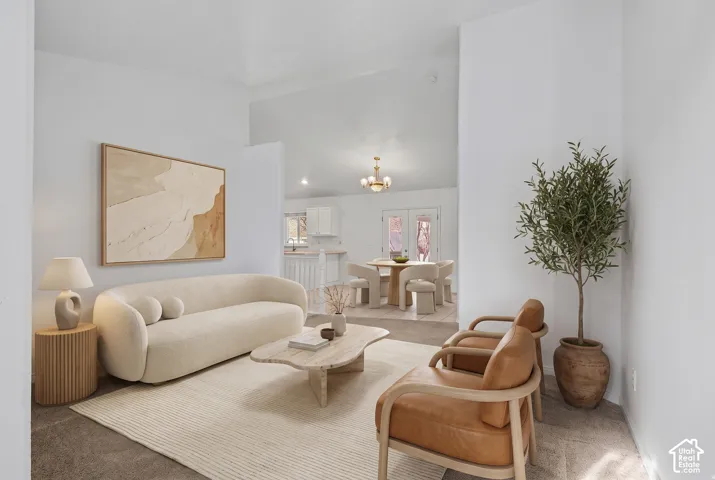Vaulted ceilings, neutral wall palette, carpeting, and overhead chandelier lighting