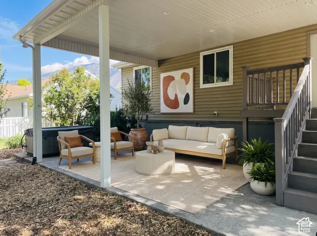 Covered concrete patio featuring recessed lighting, horizontal siding, and an attached elevated wooden staircase with railings