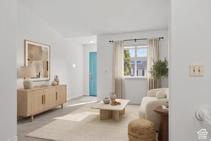 Interior space featuring vaulted ceilings, neutral wall tones, recessed lighting, and a single-panel entry door
