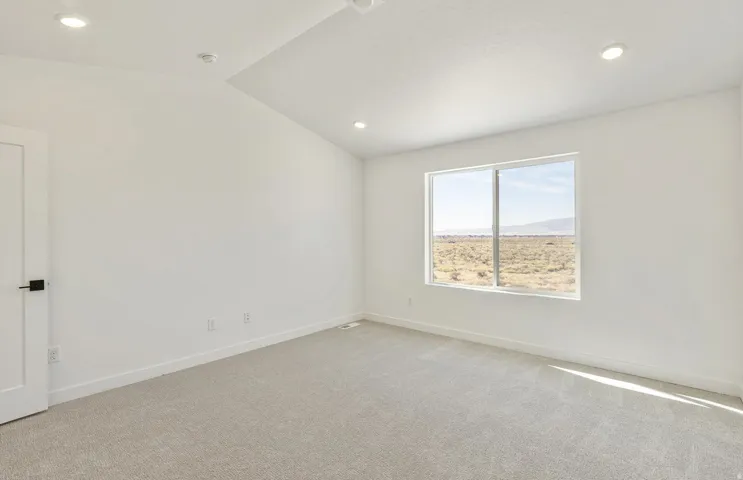 Spare room with lofted ceiling, light carpet, recessed lighting, and a mountain view