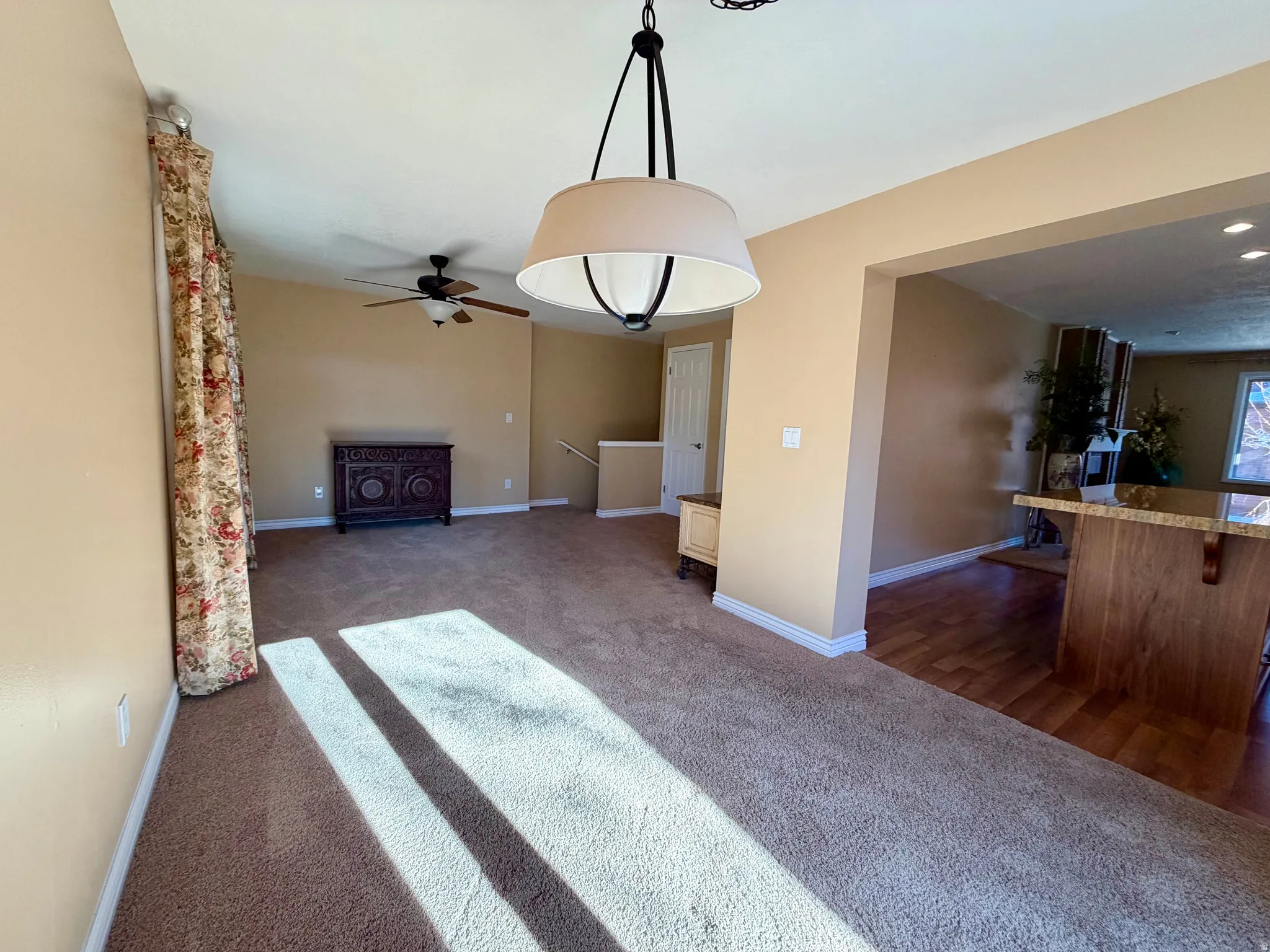 Unfurnished living room with dark carpet, a ceiling fan, and recessed lighting