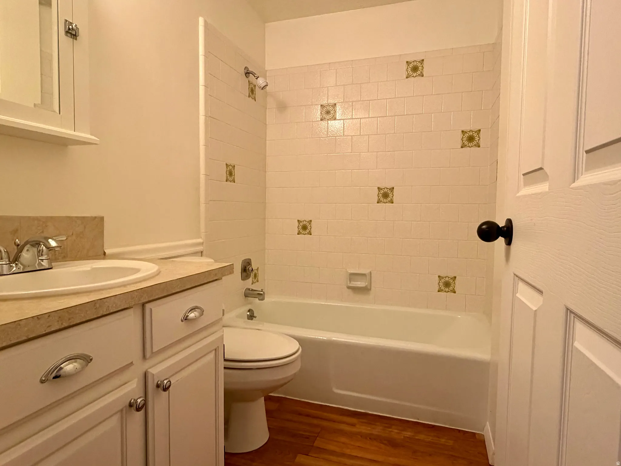 Bathroom with vanity, shower / washtub combination, and dark wood-type flooring