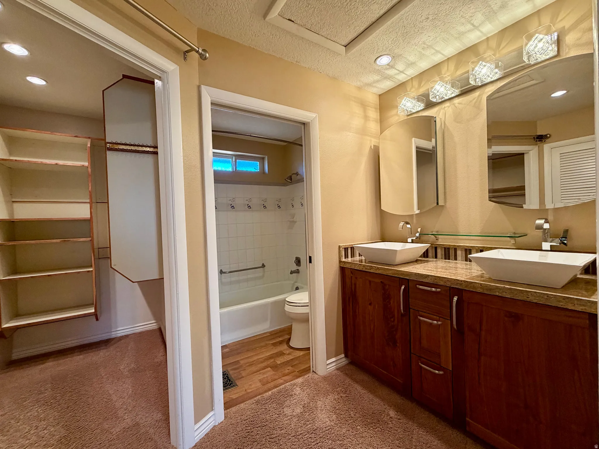 Full bathroom with recessed lighting, light colored carpet, double vanity, bathtub / shower combination, and a closet