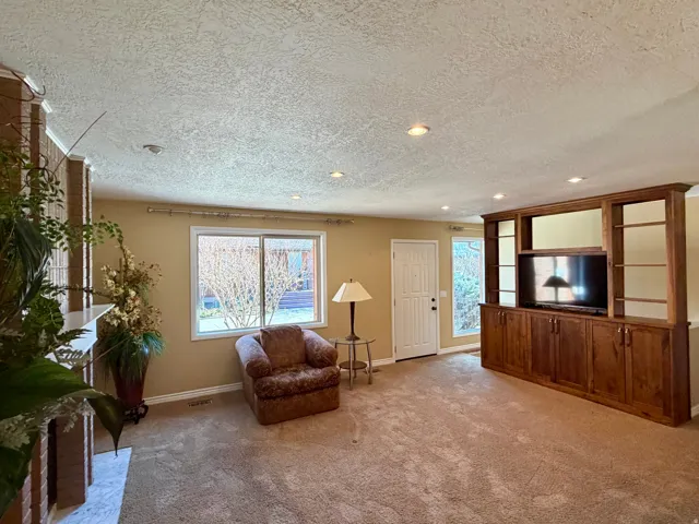 Sitting room with light carpet, a textured ceiling, and recessed lighting