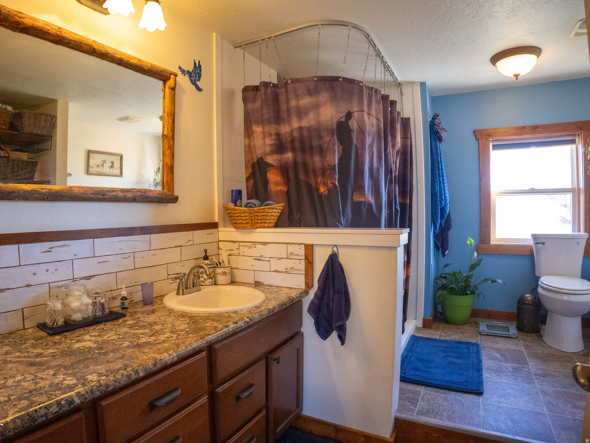 Bathroom with a shower stall, vanity, a textured ceiling, and decorative backsplash
