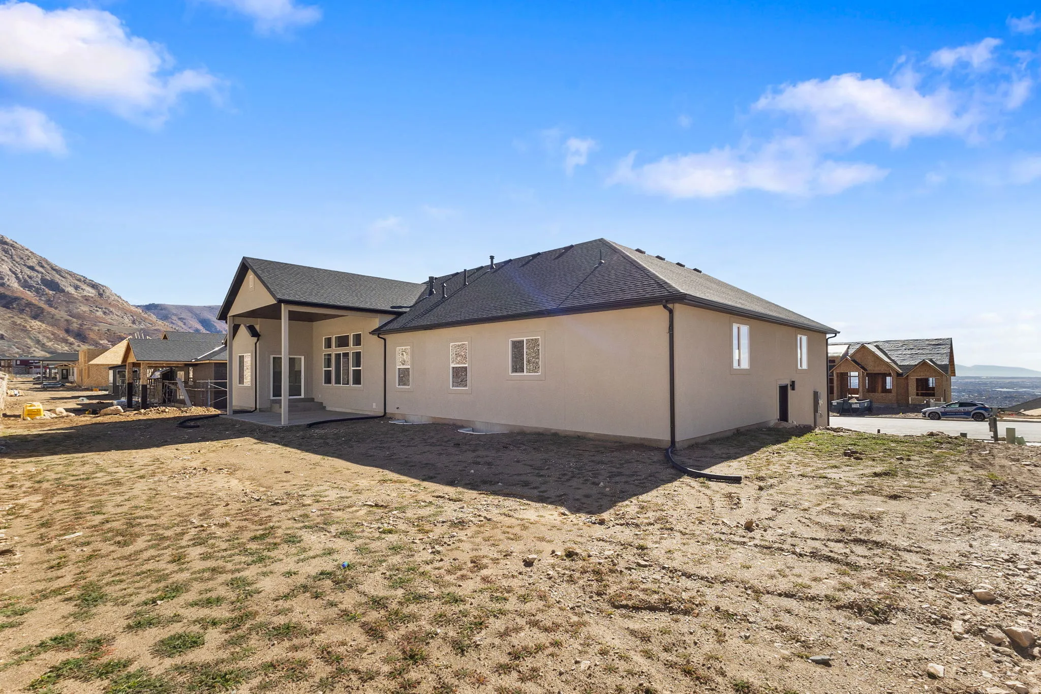 Back of house featuring a mountain view, a patio, and a shingled roof