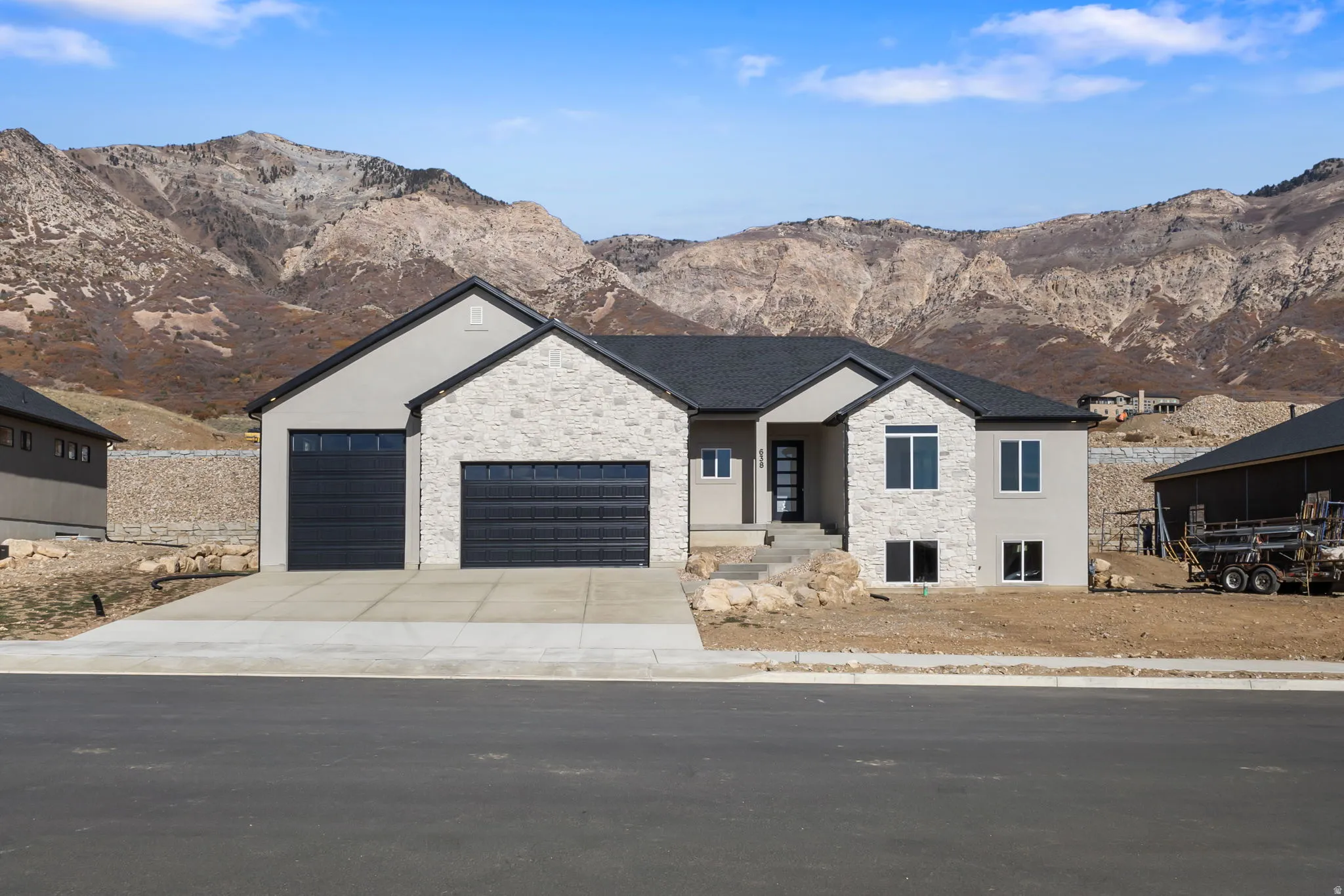 View of front facade with stone siding, a mountain view, and an attached garage