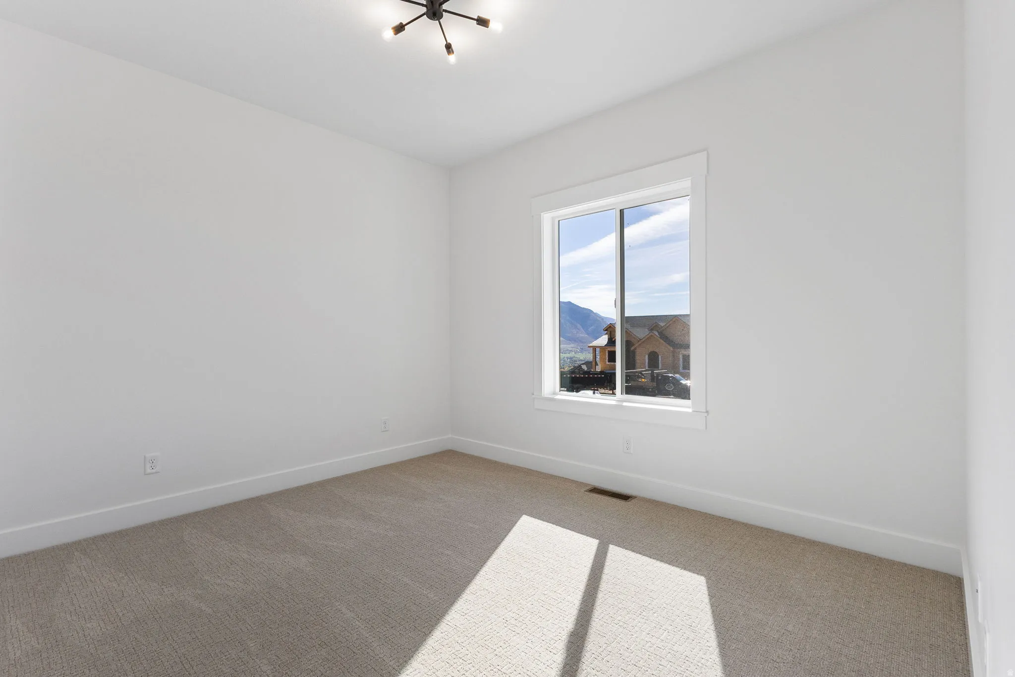 Carpeted spare room featuring baseboards and a mountain view