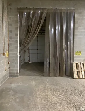 Interior space featuring unfinished concrete floors and concrete block wall