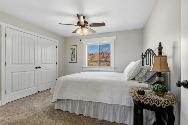 Bedroom featuring a closet, light carpet, and a ceiling fan