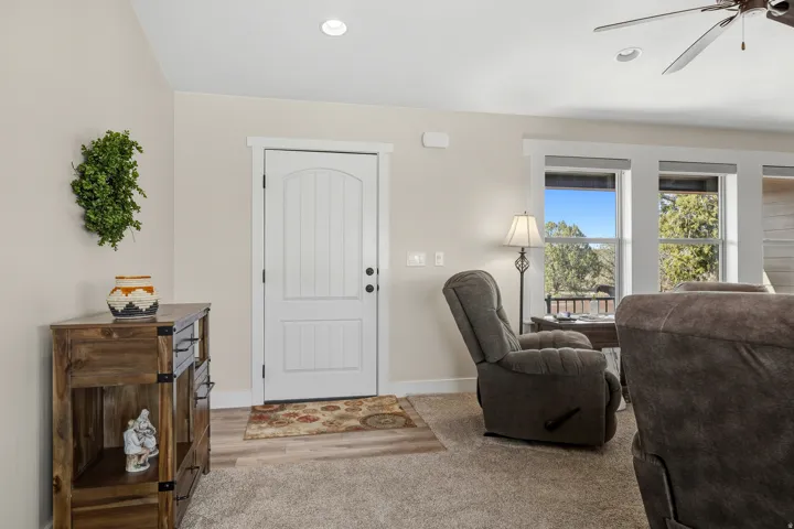 Entrance foyer with a ceiling fan and light carpet