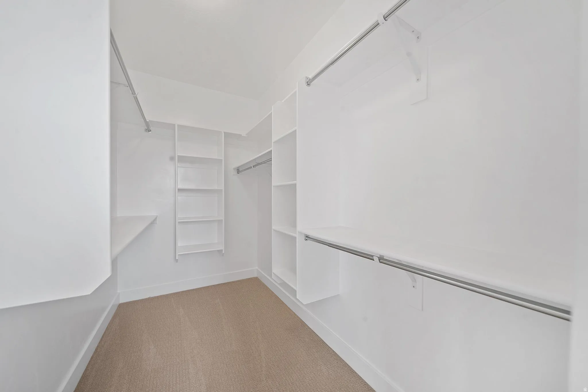 Spacious closet featuring light colored carpet