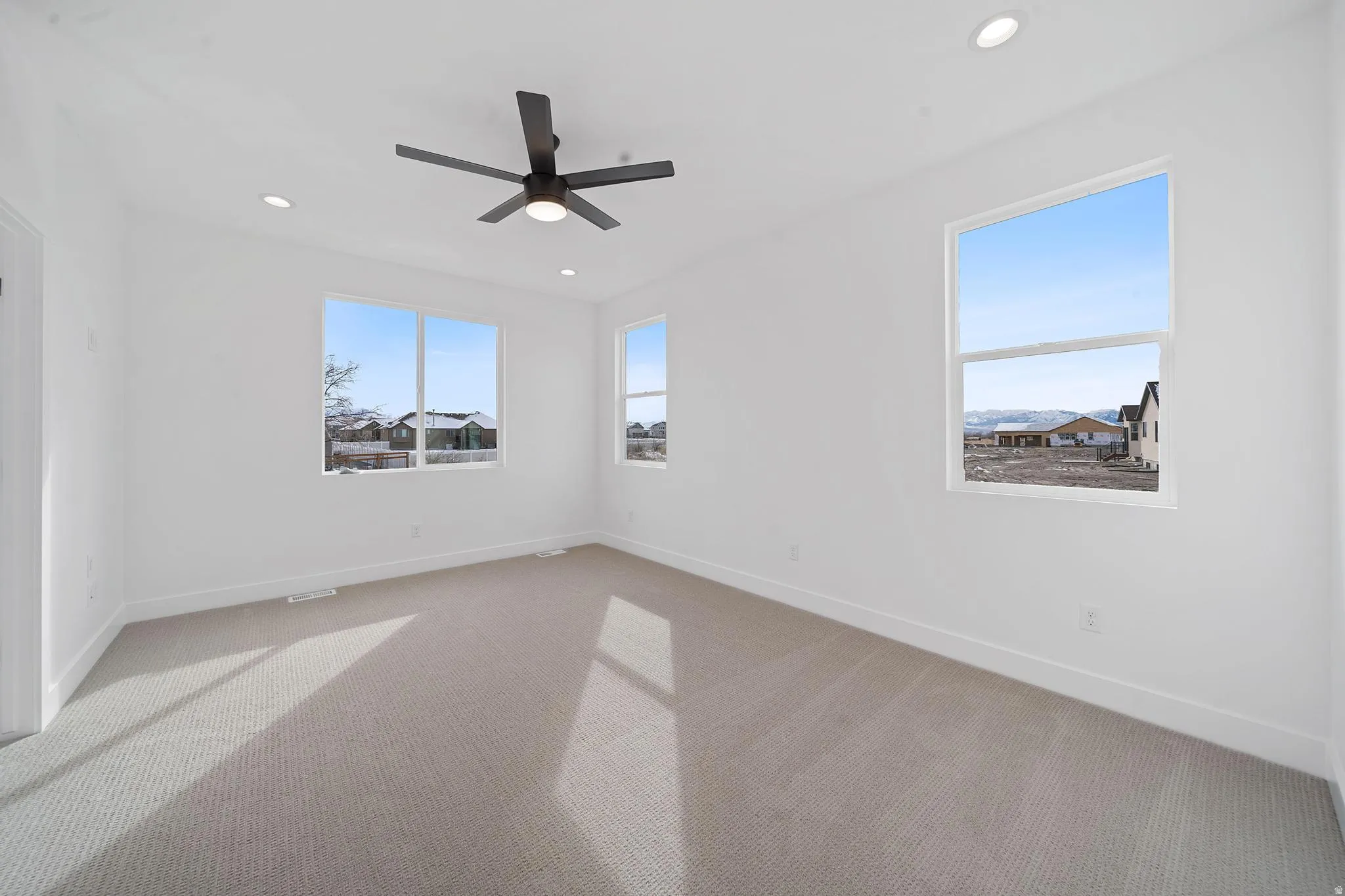 Carpeted spare room featuring recessed lighting and a ceiling fan