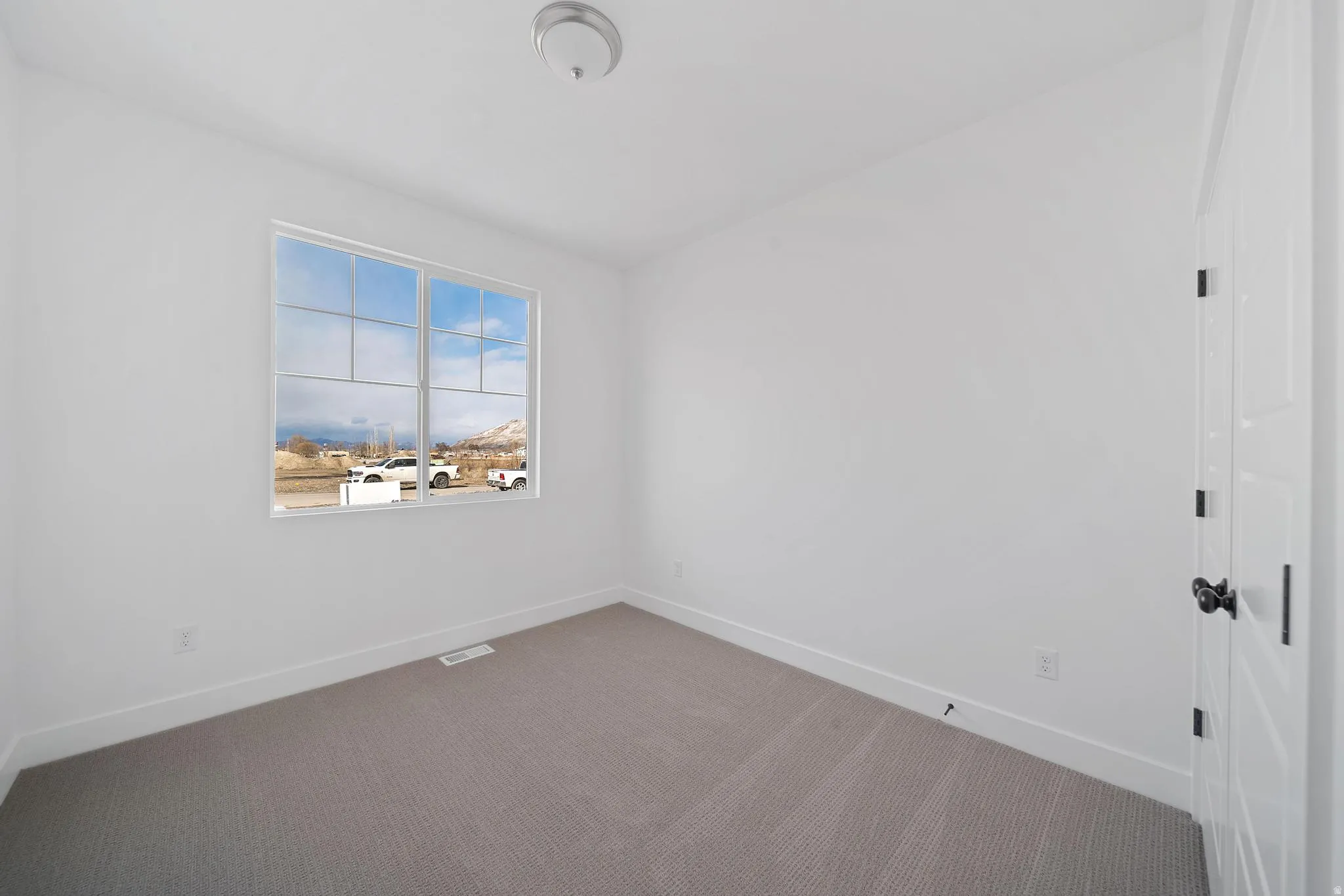 Carpeted spare room with baseboards