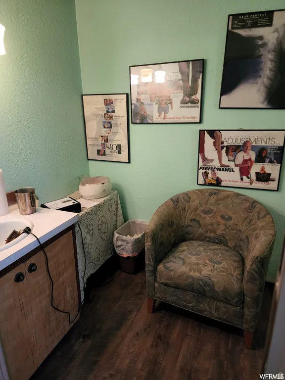 Living area featuring a textured wall and dark wood-type flooring