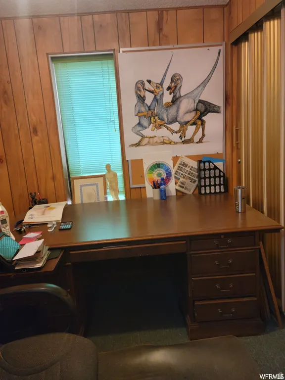 Office area with wood walls and a textured ceiling