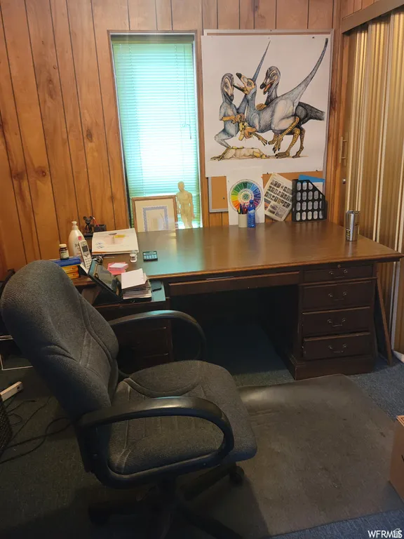 Office featuring wooden walls and carpet flooring