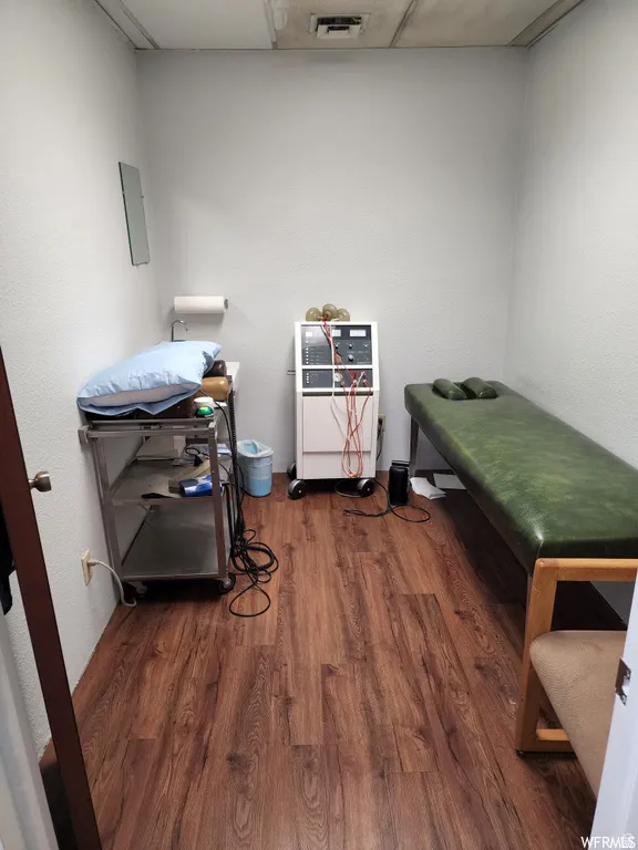 Miscellaneous room with dark wood-style flooring and a drop ceiling
