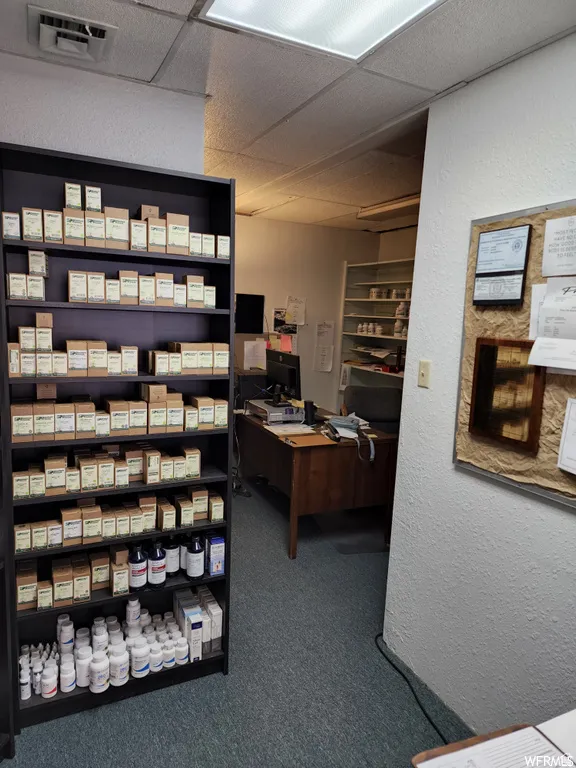 Home office with a drop ceiling and a textured wall