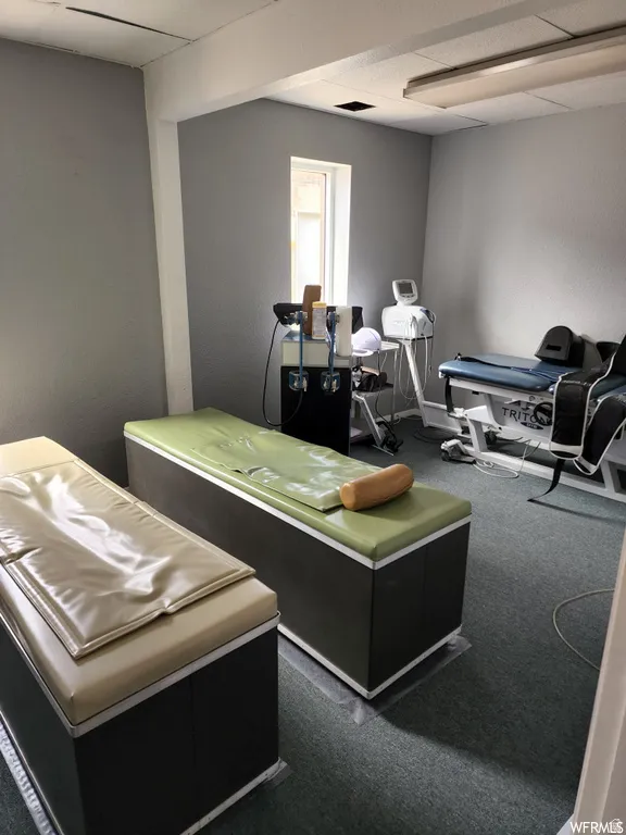 Playroom featuring a textured wall and a paneled ceiling