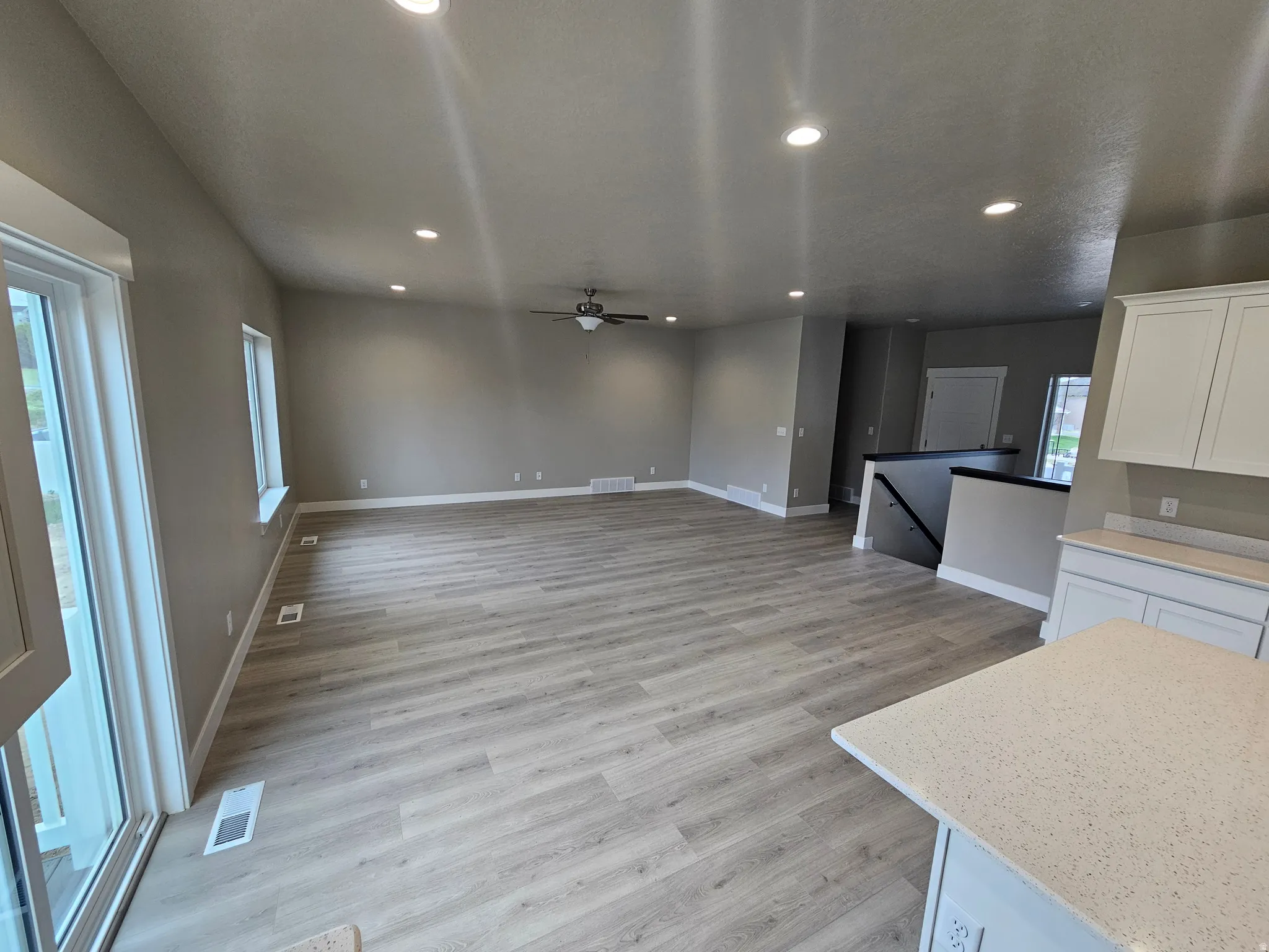 Unfurnished living room with ceiling fan, recessed lighting, and light wood-style floors