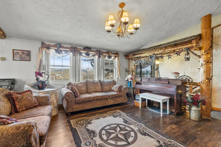 Living area with wood finished floors, a chandelier, and a textured ceiling