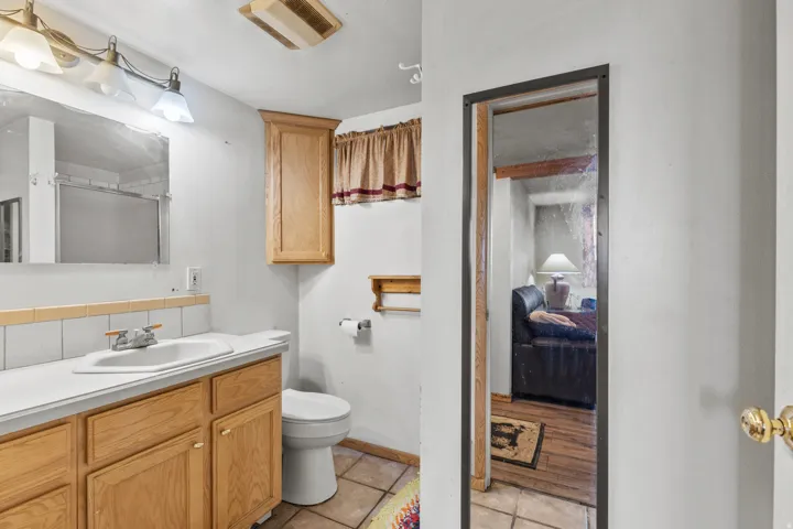 Full bathroom with vanity, a shower with door, light tile patterned flooring, and tasteful backsplash