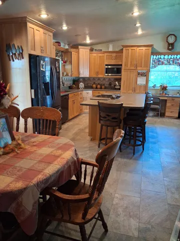 Kitchen with recessed lighting, wood-finish cabinetry, built-in microwave, a central island with integrated seating, and tile-look flooring