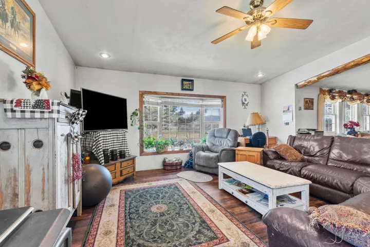 Living room with wood finished floors, recessed lighting, and ceiling fan