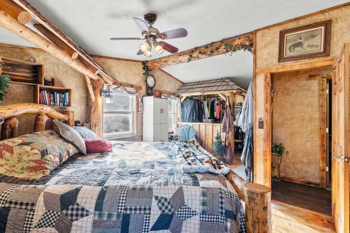Bedroom featuring wood-type flooring, ceiling fan, and vaulted ceiling