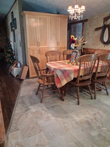 Elegant dining room featuring a round wood table, coordinating spindle-back chairs, and substantial wood cabinetry with multiple storage compartments