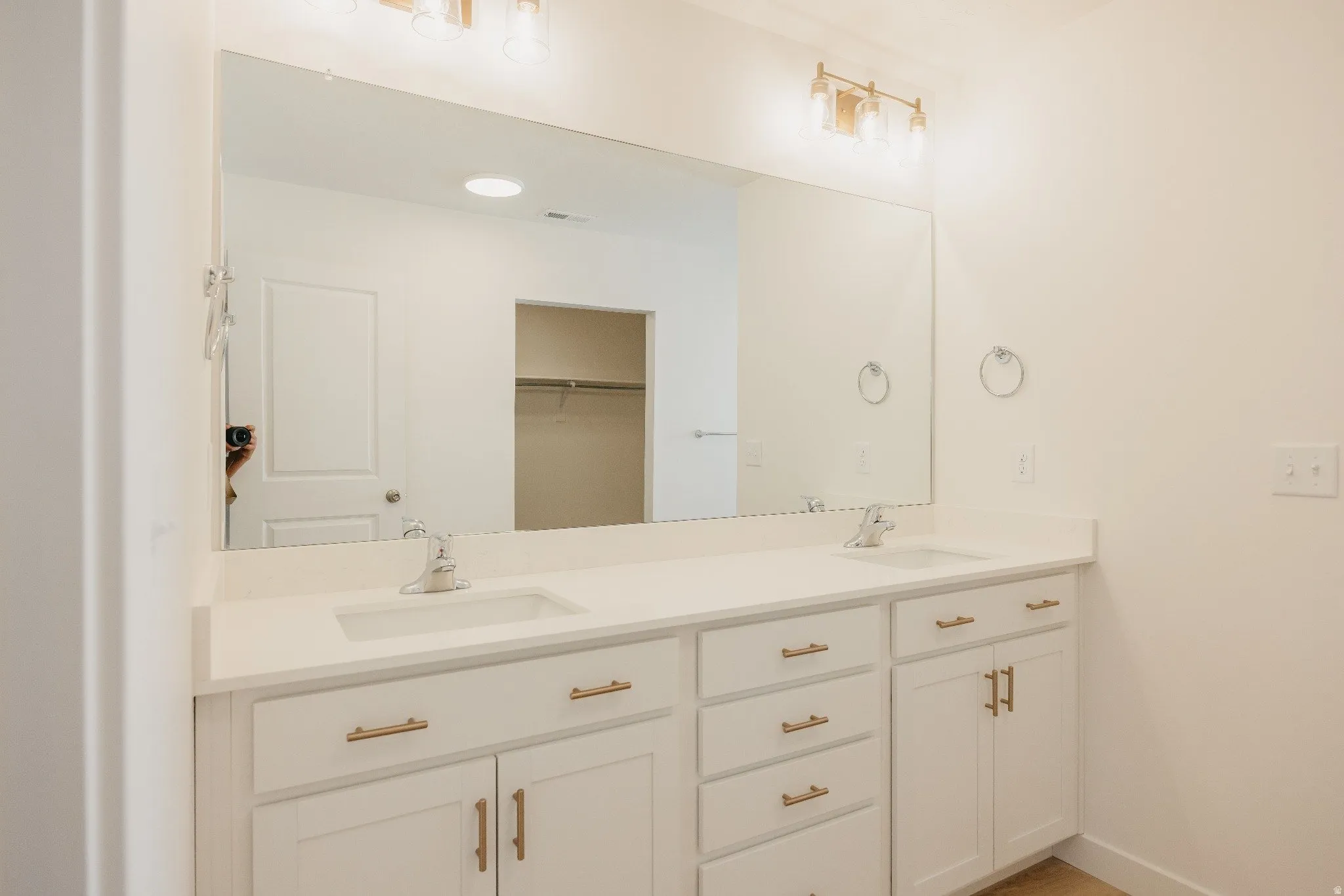 Bathroom with double vanity and a spacious closet