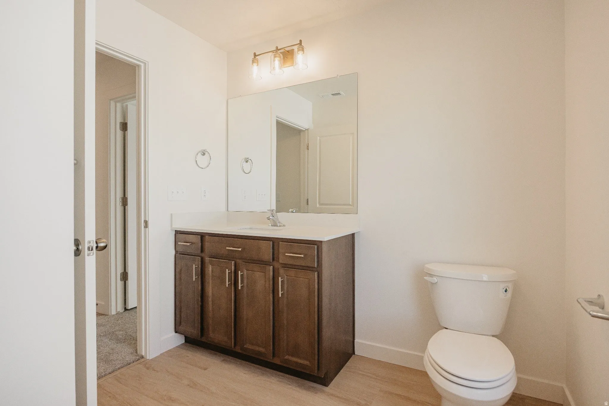 Half bathroom with vanity and light wood finished floors