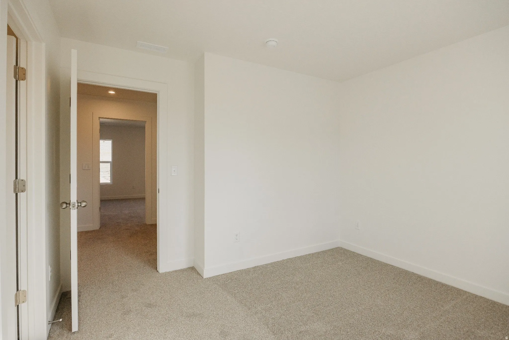 Spare room featuring light carpet and baseboards